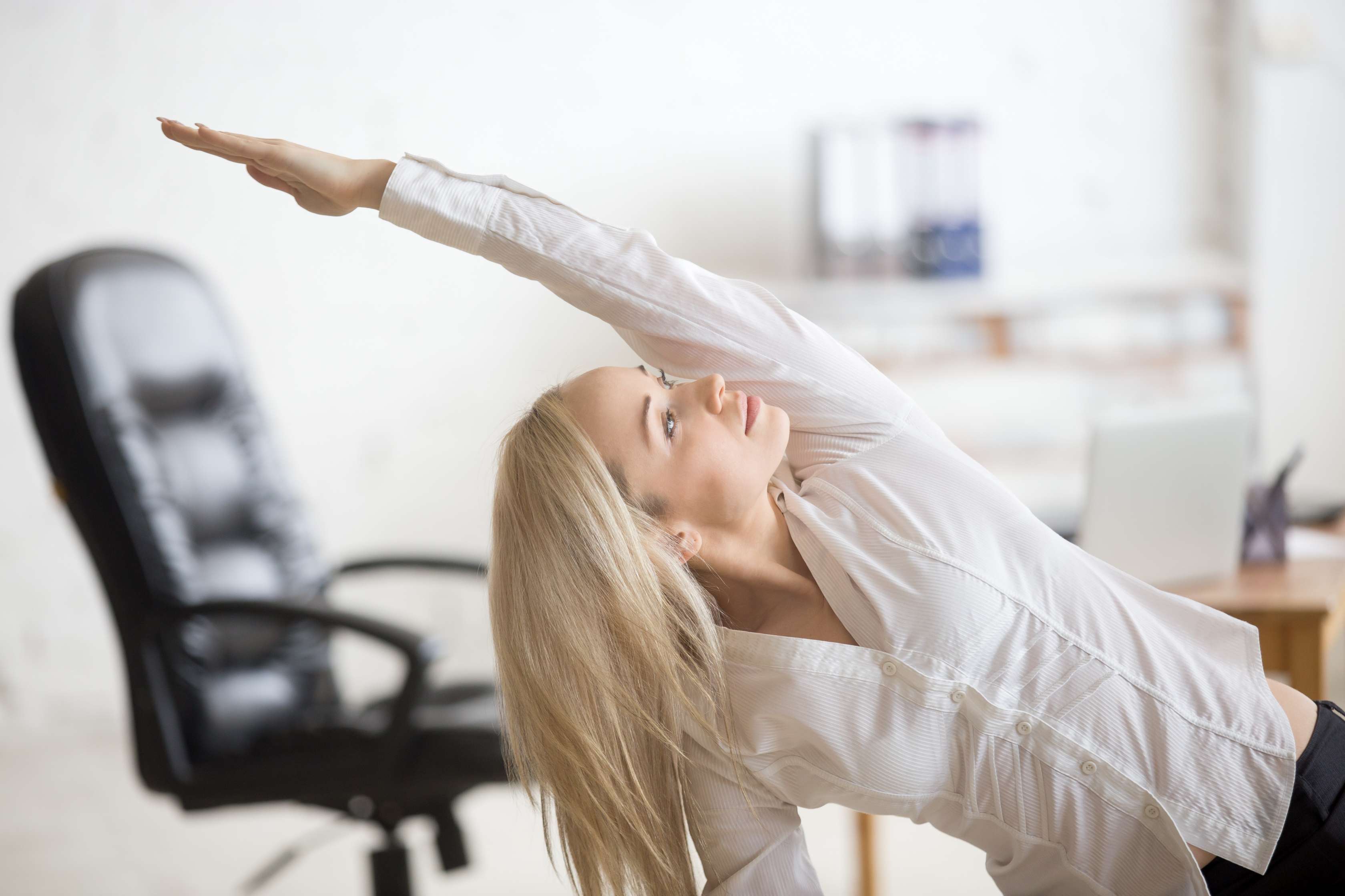 Frau dehnt sich in Büro